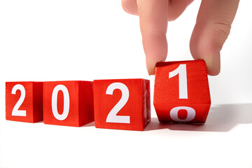 Hand holding wooden cube with flip over block 2020 to 2021