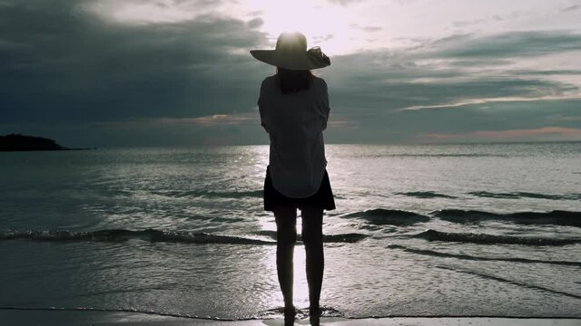 Women stand alone on the beach. Sad and disappointed woman standing by the sea