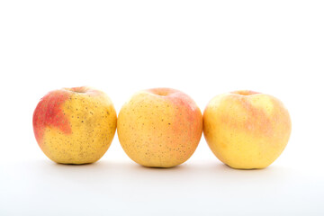 Three golden apples on white background
