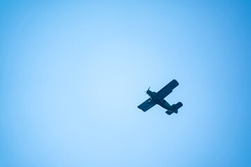 Retro green biplane plane in the blue sky