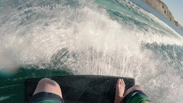 Summer Recreation Wakeskating Barefoot Behind Boat Carving the Wake Spray Slow Motion