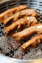 Pork steaks cooking over grill. Side view.