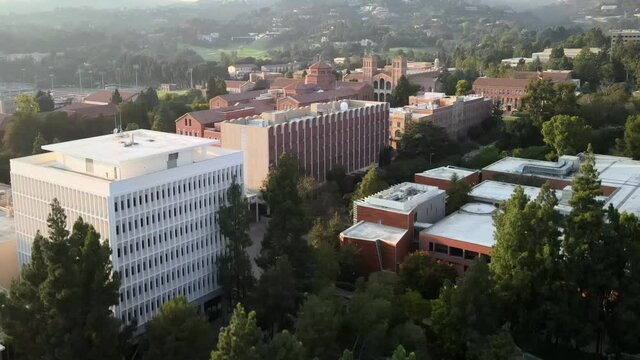UCLA university aerial view rising above Psychology department campus buildings rooftops and trees scenery