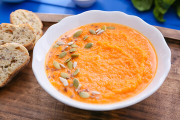 Tasty pumpkin cream soup in bowl on table