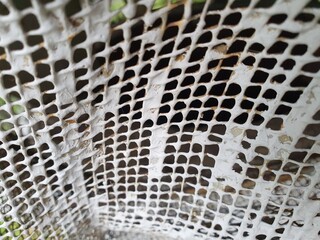 Old painted metal fencing mesh.