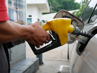 hand worker man refuelling a car at petrol station.