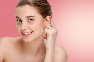 Obraz na płótnie Canvas Beautiful smiling girl with clean fresh skin posing on pink background