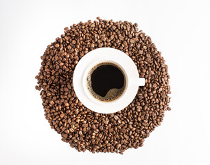 Plano cenital de una taza de café caliente americano con granos tostados de café sobre la mesa color blanco  