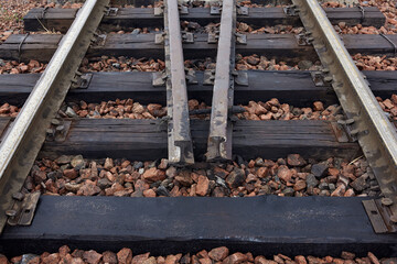 Oiled old steel rails and sleepers on rubble