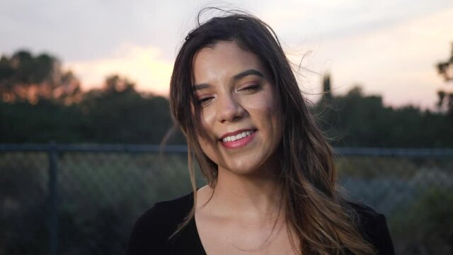A beautiful young hispanic woman smiling and looking happy at the camera with real genuine joy.