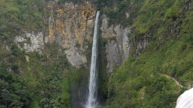 Young caucasian woman enjoying the view of Sipiso Piso Waterfall in North Sumatra, Indonesia