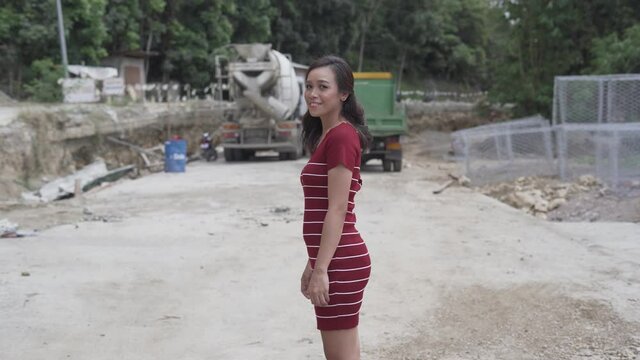 Gorgeous Filipina Girl Posing And Smiling Into The Camera In A Construction Site In The Philippines. Pre-Wedding Shoot. - medium shot