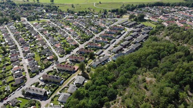 Aerial view of rows of neatly ordered houses in green suburban area