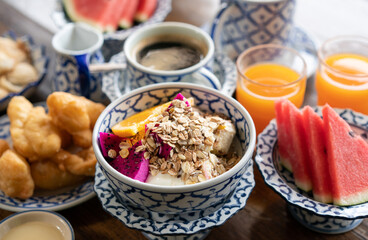 Healthy breakfast snack, granola, muesli with yogurt and tropical fruit in bowl in the morning.