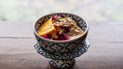 Healthy breakfast snack, granola, muesli with yogurt and tropical fruit in bowl in the morning.