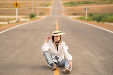 Woman alone in beautiful empty rural curve, asphalt road way.