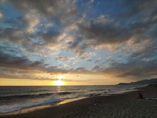Sunset on a beach landscape with windy weather and clouds on the sea shore line.