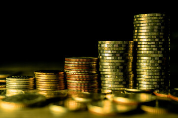 Stack of gold coins on dark background.