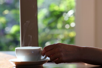 Woman working at home with laptop and a hot water drink