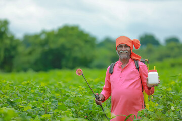 indian farmer showing fertilizer bottle at field