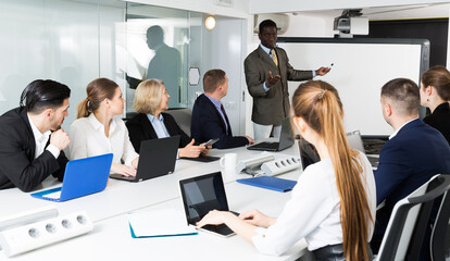 African American man giving presentation to colleagues at international business meeting