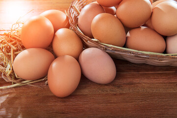 stack of raw eggs in natural basket on wood table