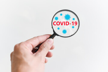 COVID-19 research and treatment concept - The doctor hand is holding a magnifying glass for search Vaccine Coronavirus COVID-19 virus