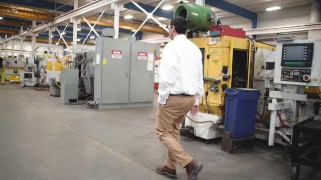 Side view of an Engineer walking into a manufacturing plant in Howell, Michigan.