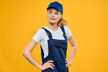Woman in working uniform blue cap delivering courier service yellow background