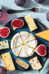 Cheese selection, elegant assortment, shot from above on a blue background