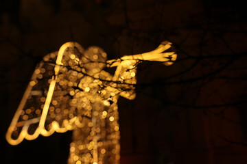 Abstract and bokeh background of luminous angel figure with christmas lights