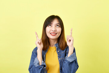 Young Asian woman pointing hands on yellow background