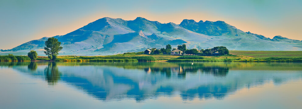 Beautiful scene with small farm near a lake and mountains behind in Dobrogea, Romania
