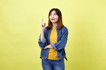 Young Asian woman pointing hands on yellow background