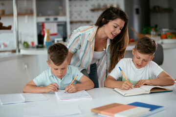 Mother helping her son with homework at home. Little boy learning at home...