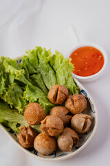 Fried meatballs and dipping sauce on a white background