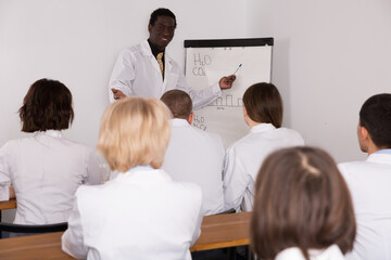 Smiling African American male professor giving presentation for medics in lecture hall