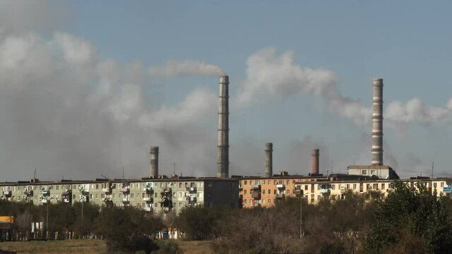A series of chimneys pumping smoke into the air, further polluting the atmosphere