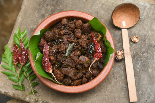Kerala style beef or Mutton dry fry. delicious spicy Beef fry in clay pot . beef curry for ghee rice, kappa, appam, parotta, puttu, bread and chappathi, beef roast. Indian cuisine .