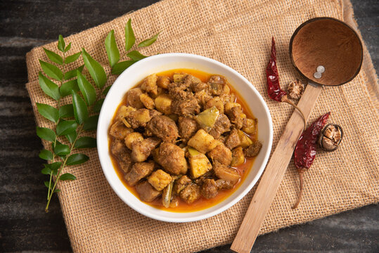Traditional homemade Pork curry from Asian cuisine. Goan Pork vindaloo. Spicy delicious meat beef curry. Bowl of tasty mutton Indian spices. side dish of Ghee rice, Appam, Parotta, Puttu