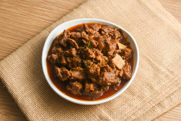 Traditional homemade Mutton curry from Asian cuisine.   Chukhandar gosht. Spicy delicious meat beef curry.  Bowl of tasty mutton roast Indian spices.  side dish of Ghee rice, Appam, Parotta, Puttu