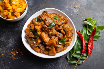 Traditional homemade Mutton curry from Asian cuisine.   Chukhandar gosht. Spicy delicious meat beef curry.  Bowl of tasty mutton roast Indian spices.  side dish of Ghee rice, Appam, Parotta, Puttu