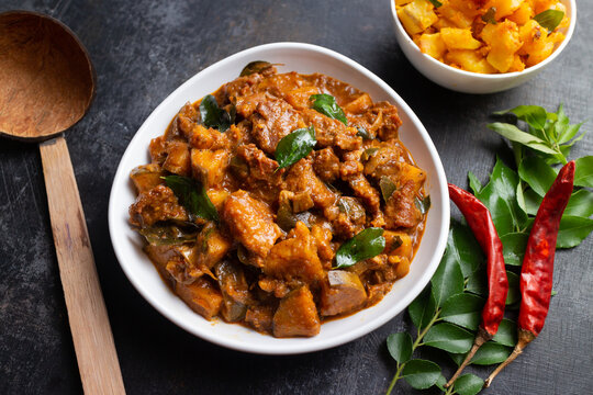 Traditional homemade Mutton curry from Asian cuisine.   Chukhandar gosht. Spicy delicious meat beef curry.  Bowl of tasty mutton roast Indian spices.  side dish of Ghee rice, Appam, Parotta, Puttu