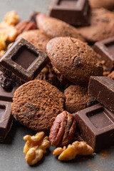 Sweet background, chocolate slices, cookies and mixed nuts on concrete background with copy space.