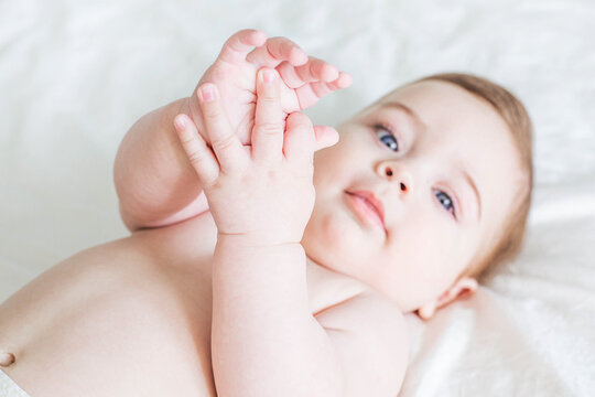Newborn baby boy naked on bed , show hands