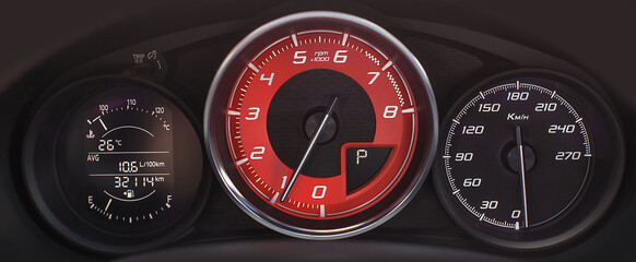 
modern car speedometer and dashboard. red and black car interior details. close up