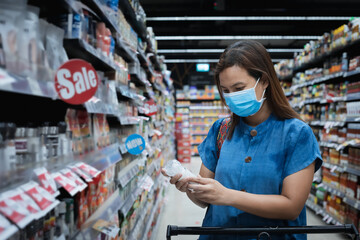 Asian woman wearing mask over her face while grocery shopping in supermarket for healthcare and preventive from coronavirus Covid 19 pandemic as new normal requirement.