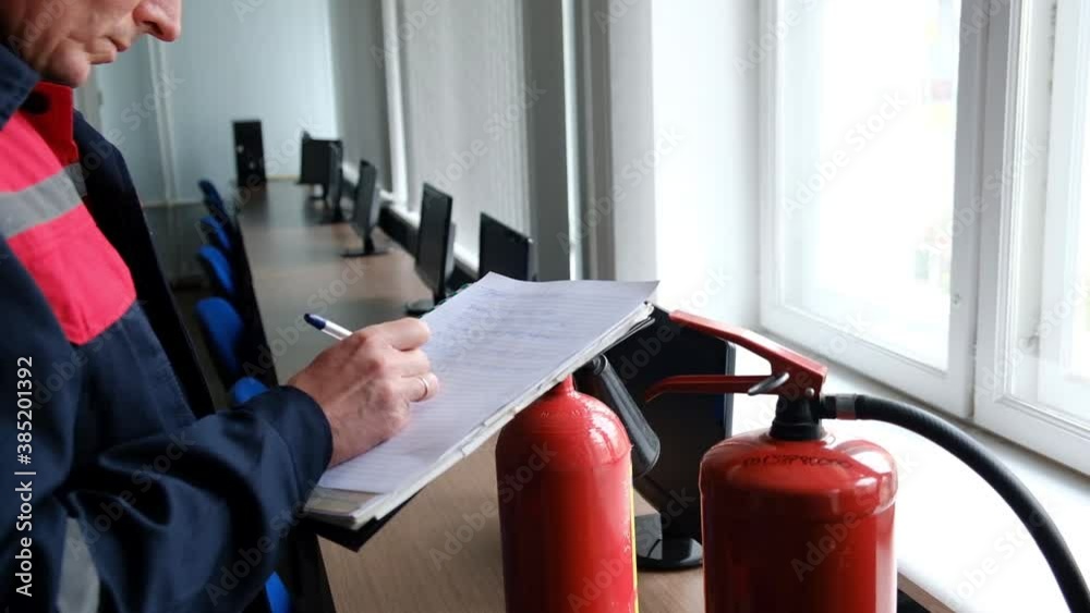 Wall mural engineer professional are checking a fire extinguisher and writes data to the check log. fire alarm 