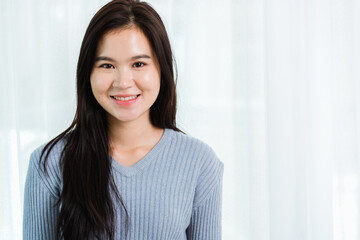 Close up headshot portrait young Asian happy beautiful woman healthy smiling face long hair, studio shot looking to camera at home and have a copy space for your text