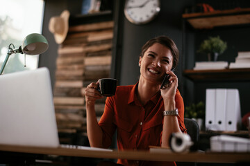 Businesswoman using phone. Happy young woman talking to the phone in office..